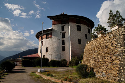 Houses by building against sky