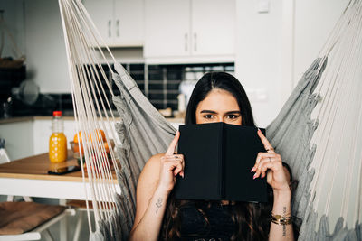 Portrait of woman reading book at home