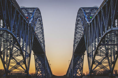 Low angle view of metallic bridge against clear sky during sunset