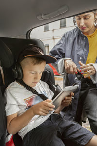 Man using mobile phone while sitting in bus