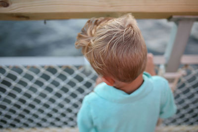 Rear view of boy standing on pier 