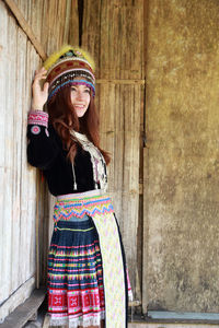 Portrait of woman standing against wall