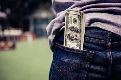 Close-up of us paper currency in jeans pocket