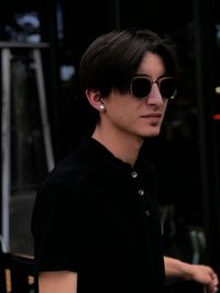 Close-up of young man wearing sunglasses while standing outdoors