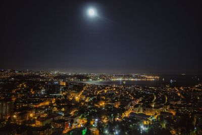 Illuminated cityscape against sky at night