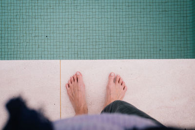 Low section of woman standing by swimming pool