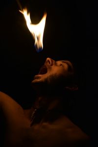 Close-up of a man against black background