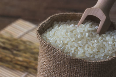 Close-up of rice in sack on table