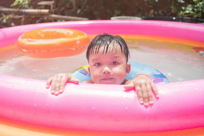Portrait of boy swimming in wading pool