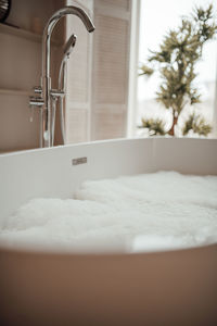 Luxury interior of big bathroom at modern african style with oval bathtub in natural lighting