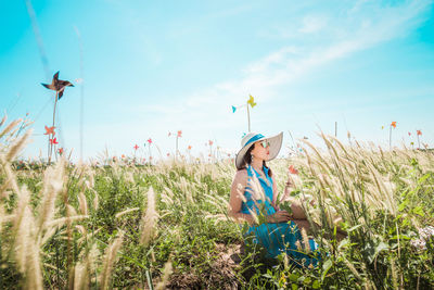 Rear view of girl on field against sky