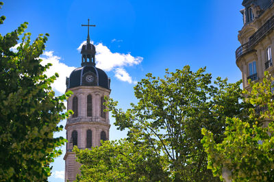 Low angle view of trees and building against sky