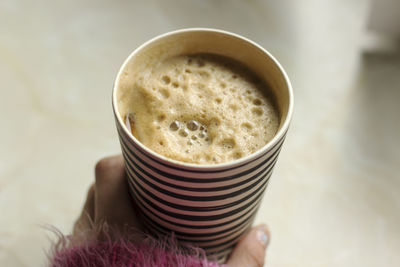 Close-up of hand holding coffee cup