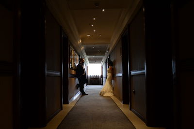 Well dressed bride and groom standing in corridor