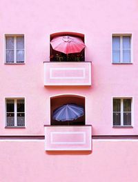 Front look at minimal facade with balconies and windows 