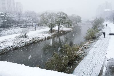 Frozen river in city during winter