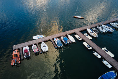 Aerial top view of boats near wooden pier at lake