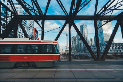 Train at railroad station in city against sky