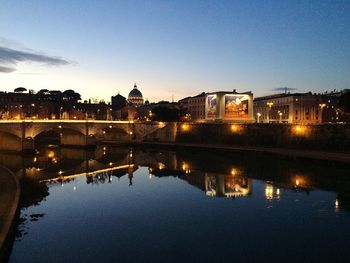 Illuminated bridge over river at night