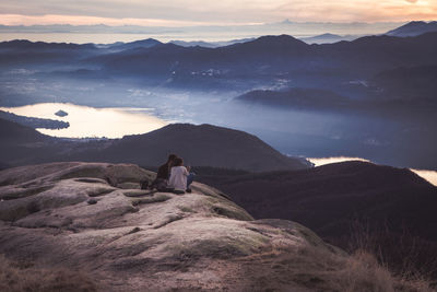 Man photographing mountains against sky