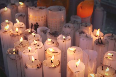 Close-up of lit candles on table in temple