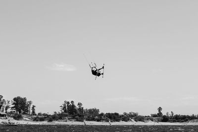 Helicopter flying over water against sky