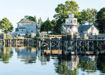 Bass harbor maine with houses and lobster traps stacked on docks all reflecting in the water