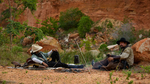 A cowboy man sitting and resting to smoke to relax