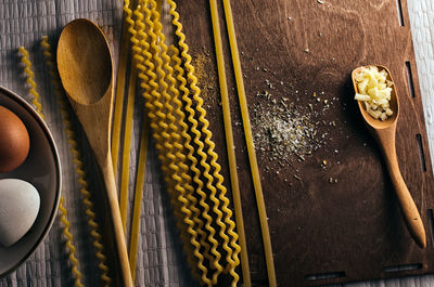 High angle view of raw pasta with cheese and eggs at table