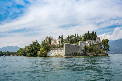 Villa borghese at isola der garda castle by sea against sky in city