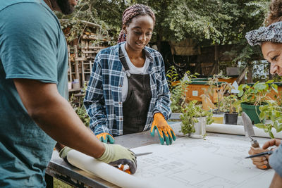 Female and male volunteers examining blueprint in community garden