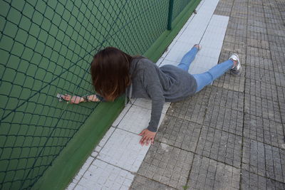 High angle view of girl lying on footpath