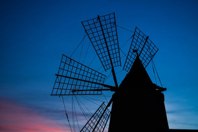 Low angle view of traditional windmill against blue sky