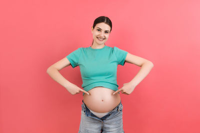 Portrait of a smiling young woman against red background