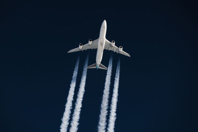 Low angle view of airplane flying against sky