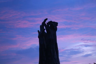 Low angle view of silhouette hand against sky at sunset