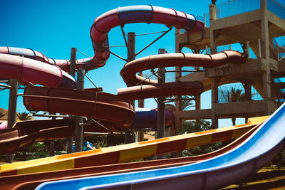 Low angle view of amusement park ride against blue sky