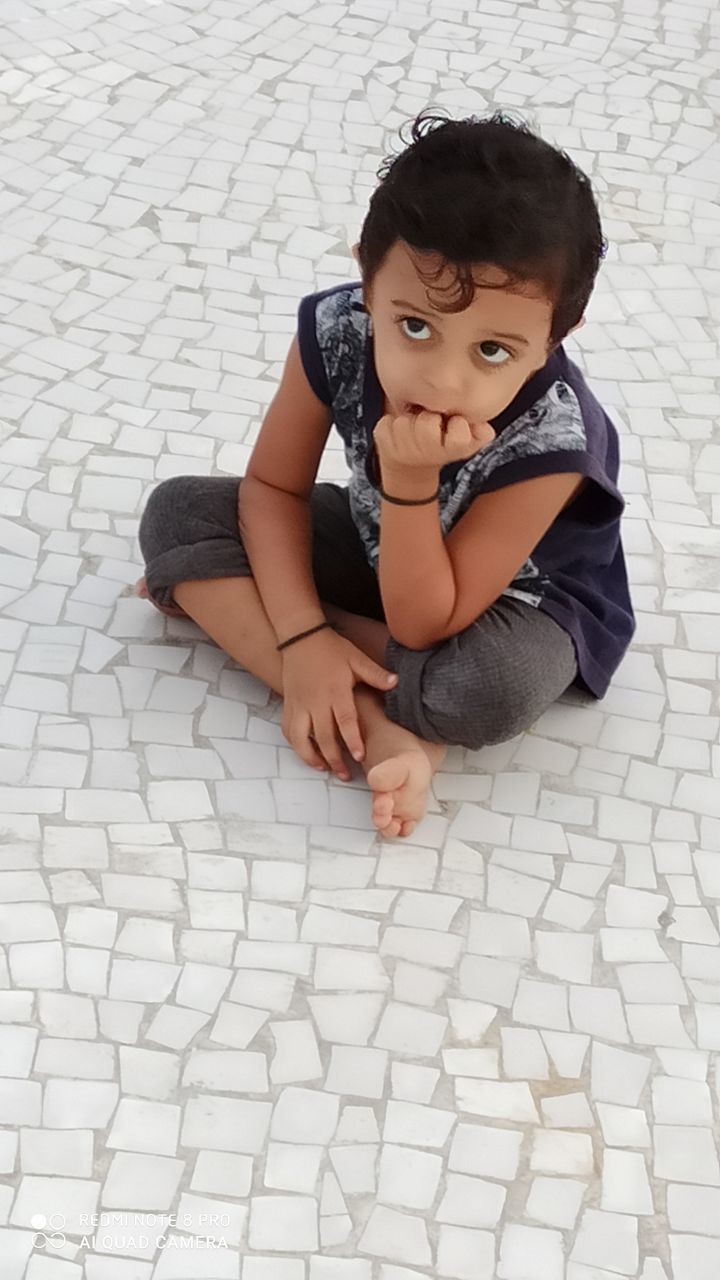 HIGH ANGLE VIEW OF BABY SITTING ON FOOTPATH