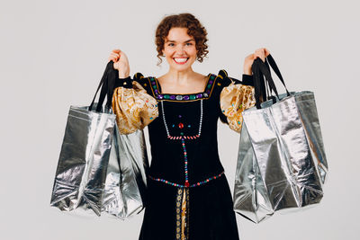 Portrait of young woman standing against white background