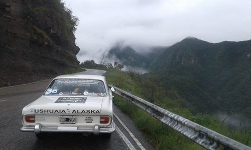 Cars on road against mountain range