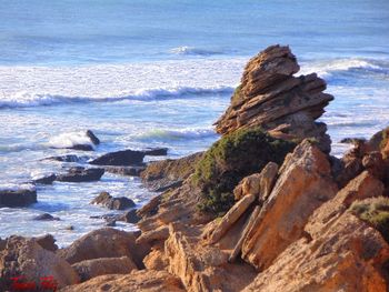 Rocks on sea shore against sky