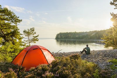 Young man camping by lake