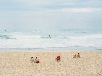 People standing on beach against sky