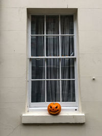 Low angle view of orange window on wall of building