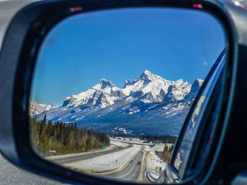 Close-up of snow on side-view mirror of car