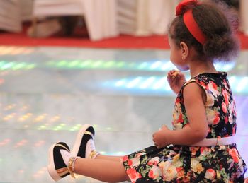 Side view of a girl sitting outdoors