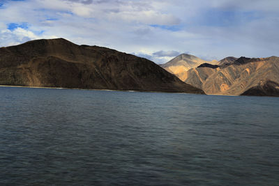 Scenic view of sea and mountains against sky