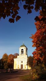 Low angle view of trees and building against sky