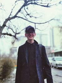 Portrait of smiling young man standing in city