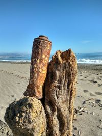 Close-up of rock on beach against clear sky